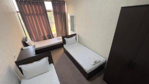 a small room with two beds and a window at Sohil Hotel in Stantsiya Kyzyl-Tukumachi +10 photos