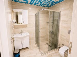 a bathroom with a shower and a toilet and a sink at Mavi OTEL BOUTİQUE RESTAURANT in Mahmutlu