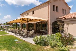 a patio with tables and chairs under an umbrella at Glamping Tenuta Ca'Nova in Mestrino +18 photos
