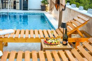 a pool with a table with a bowl of fruit and wine glasses at Villa Beyond Bar in Bar