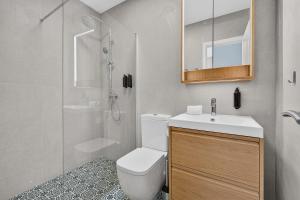 a bathroom with a toilet and a sink and a shower at Coast Suites in Alcalá