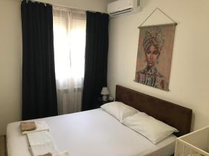 a bedroom with a bed and a painting on the wall at First Choice Apartment in Skopje