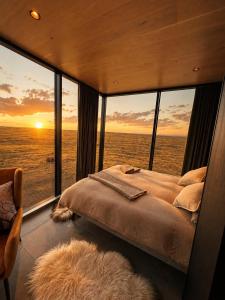 a bedroom with a bed with a view of the ocean at Camp Boutique in Gaulverjabær