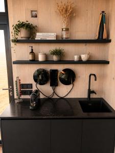 a kitchen with a black counter with a sink at Camp Boutique in Gaulverjabær