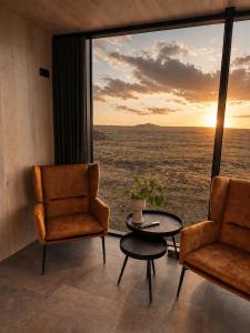 a room with two chairs and a table in front of a window at Camp Boutique in Gaulverjabær
