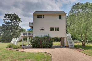 a large white house with a staircase leading up to it at Pool, Dock + Rooftop Views! Bohannon Getaway in Bohannon