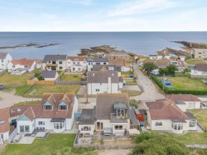 an aerial view of a houses in front of the ocean at 5 Bed in Beadnell oc-24955 in Beadnell