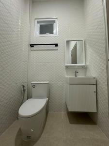 a white bathroom with a toilet and a sink at The Summer Cozy Cottage 2 in Haad Chao Phao +19 photos