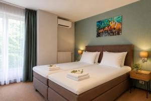 a bedroom with a large bed with white sheets at Hotel 't Paviljoen in Rhenen