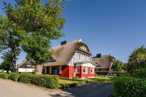 a red and white house with a gray roof at Jade 1 in Born