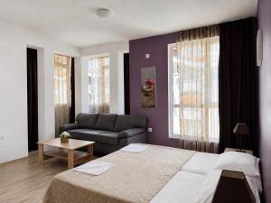 a bedroom with a bed and a couch at Vanilla Garden Apartments in Sunny Beach