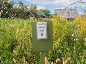 a sign in the middle of a field of grass at Eco Farm Tayssir Marrakech in Marrakesh