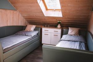 two beds in a small room with a window at Pokoje Gościnne Sandomingo in Sandomierz