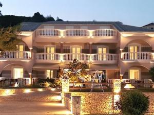 a large white house with lights in front of it at Marathon Studios & Apartments in Keri