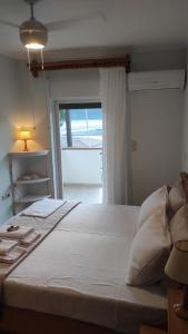 a bedroom with a large white bed with a window at Vasiliki Bay in Vasiliki