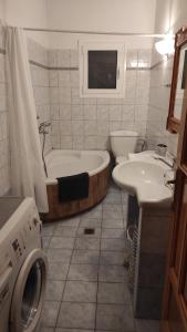 a bathroom with a tub and a toilet and a sink at Vasiliki Bay in Vasiliki