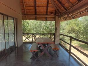 a picnic table and two benches on a porch at Khoneni in Marloth Park