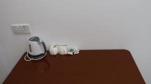 a table with a coffee maker and white cups on it at Adam's Palm Resort in Talaimannar