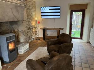 a living room with chairs and a television with an american flag at La grée des dinosaures in Saint-Gravé