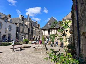a group of people walking down a street with buildings at La grée des dinosaures in Saint-Gravé