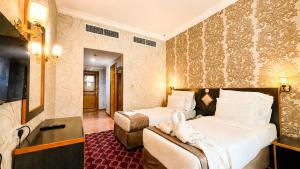 a hotel room with two beds and a television at Elite Jonrad Hotel LLC in Dubai +14 photos