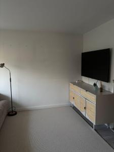 Ein Wohnzimmer mit einem Flachbildfernseher an einer weißen Wand in der Unterkunft Syltfisch in Sylt