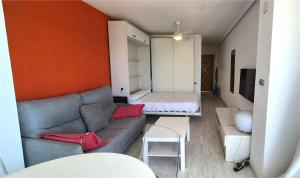 a living room with a couch and a bed at Estudio playa in Bellreguart +7 photos
