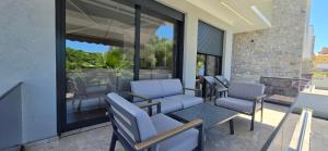 a patio with chairs and a table and windows at Villa Castro in Ulcinj