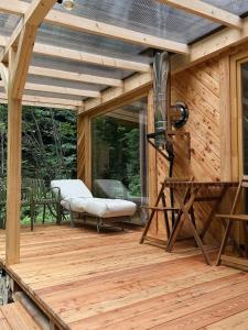 a large wooden deck with a bench on it at Tiny nad potokiem - Leśny in Sidzina +11 photos