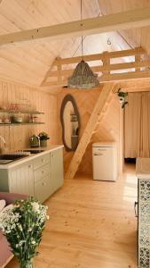 a kitchen with a staircase in a wooden house at Tiny nad potokiem - Leśny in Sidzina