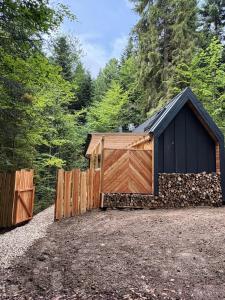 a barn with a wooden gate and a fence at Tiny nad potokiem - Leśny in Sidzina