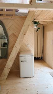 a wooden attic with a small refrigerator in a room at Tiny nad potokiem - Leśny in Sidzina