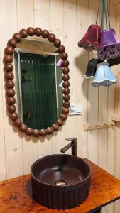 a bathroom with a wooden mirror and a sink at Tiny nad potokiem - Leśny in Sidzina