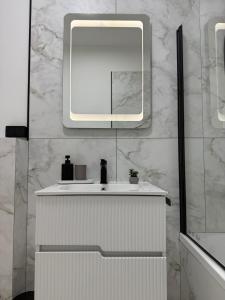 a bathroom with a white sink and a mirror at Sky Residence House in Cluj-Napoca +18 photos