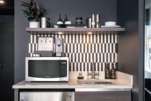 a kitchen with a counter with a microwave and a sink at Broadway Hotel in the Flatiron District in New York