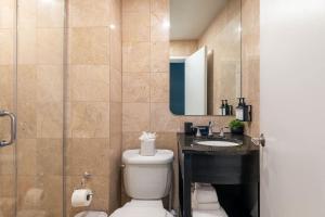 a bathroom with a toilet and a sink and a mirror at Broadway Hotel in the Flatiron District in New York
