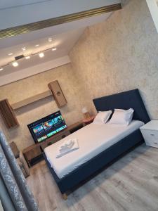 a bedroom with a large bed and a flat screen tv at MEM Studio in Mamaia Sat/Năvodari