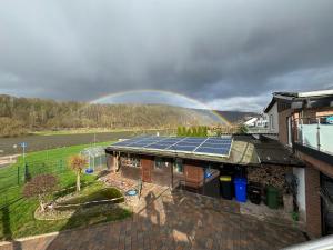 a rainbow over a house with a house with solar panels at Roxy in Beverungen