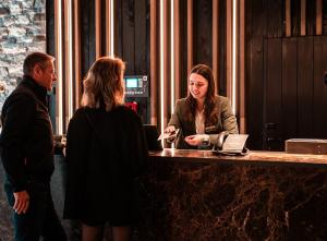 a group of people standing around a counter at Hôtel Le Sanglier des Ardennes in Durbuy