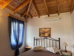 a bedroom with a bed and a blue curtain at Akrojali in Kómboi