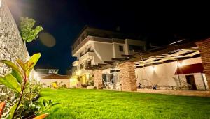 a house with a lawn in front of it at night at Къщата в Ахелой in Aheloy