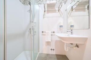 a bathroom with a sink and a shower at Hotel Centro Vitoria AutoCheckIn in Vitoria-Gasteiz +35 photos
