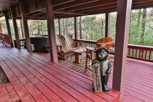 a bear statue holding a sign on a porch at Living on the Ledge - Long-Range Mountain Views - Hot Tub and Fire Pit in Blue Ridge