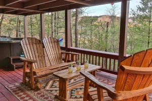 a porch with three wooden rocking chairs and a table at Living on the Ledge - Long-Range Mountain Views - Hot Tub and Fire Pit in Blue Ridge