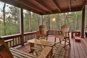 a porch with two chairs and a table on it at Living on the Ledge - Long-Range Mountain Views - Hot Tub and Fire Pit in Blue Ridge