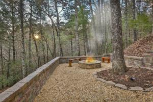 a fire pit next to a tree in the woods at Living on the Ledge - Long-Range Mountain Views - Hot Tub and Fire Pit in Blue Ridge +14 photos