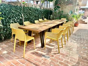 a long wooden table and chairs on a brick patio at Къщата в Ахелой in Aheloy +41 photos