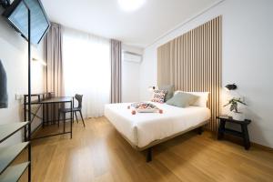a bedroom with a bed and a table and a desk at Hotel Centro Vitoria AutoCheckIn in Vitoria-Gasteiz