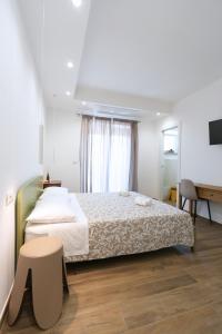 a bedroom with a bed and a table and a window at Leukos Home Relais Ecoretreat b&b in Diamante