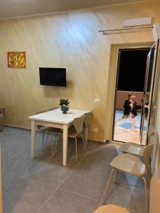 a dining room with a table and chairs and a tv at Villa Silla - Casa Vacanze in Delia